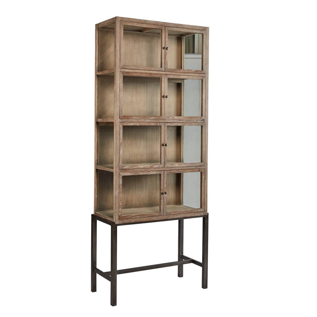 The Harlow Curio Cabinet is a tall reclaimed oak display cabinet with a natural finish, set on a black metal base. It offers eight glass-fronted cubbies for elegant storage and display.