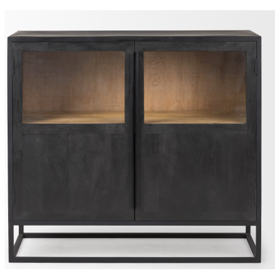 The Obsidian Media Cabinet boasts an elegant design with its dark mango wood doors and two glass panels, which showcase a light wooden interior. Supported by a minimalist rectangular metal frame, it offers cable management ports and presents a sleek, modern appearance that emphasizes the contrast between its exterior and warm interior.