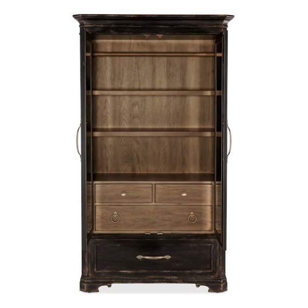 The Florence Wardrobe Cabinet is tall and black with a distressed finish, glass doors, and a natural wood interior. It features two open shelves, two small drawers with round metal pulls, and a large bottom drawer with a curved handle.