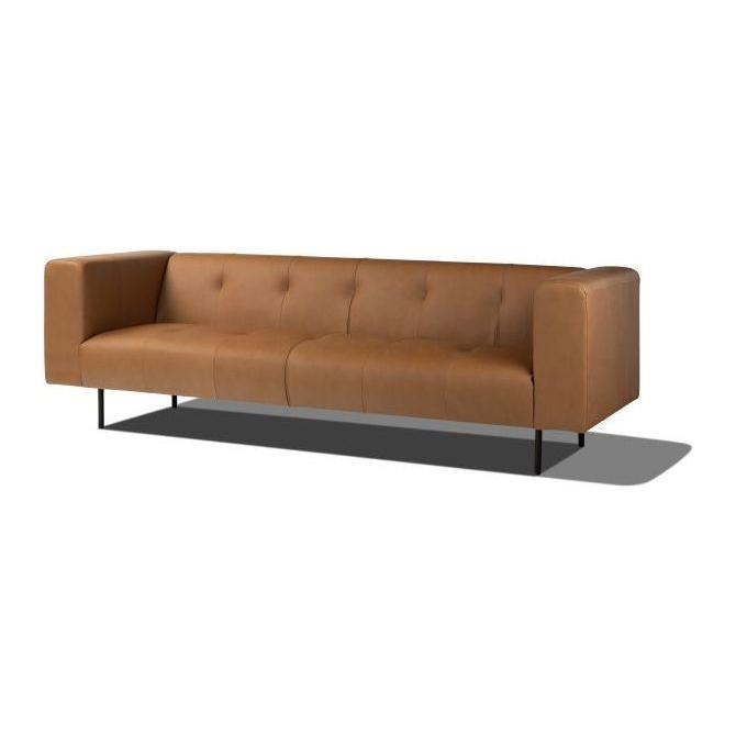 The Copper Leather Sofa is a sleek, modern piece in luxurious brown top grain leather. It features a minimalist design with a low backrest, straight armrests, three seat cushions, and stands on slender black metal legs that cast shadows on the white background.
