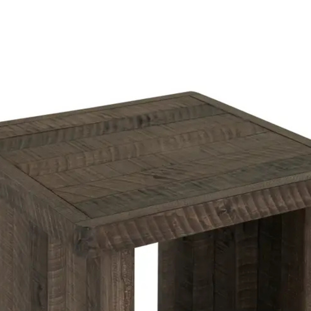 A close-up of the Monte Wood Side Table reveals its square top, visible wood grain, and dark brown driftwood finish. Straight edges and rustic texture highlight the organic patterns; only a portion of this side table is shown.
