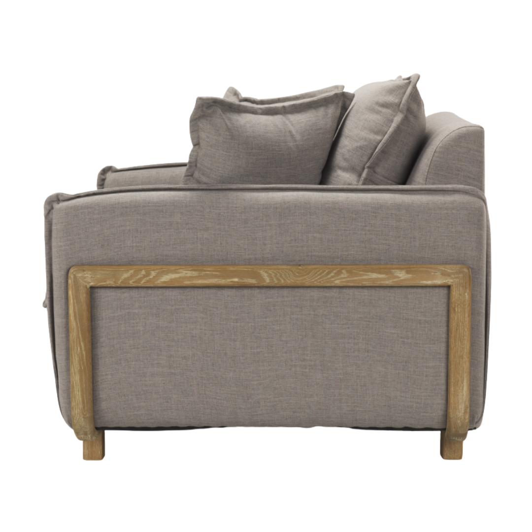 The Veyra Plush Upholstered Armchair in Earthy Grey boasts a side view that highlights its stylish elegance with plush cushions. Wooden frame accents on the back and bottom lend a rustic touch, while its clean lines and modern comfort design offer a cozy, contemporary vibe.