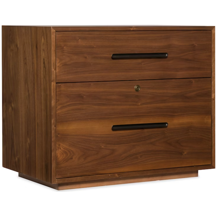 The Soren Walnut Lateral File is a wooden two-drawer cabinet with a warm walnut finish and visible grain. It features long black handles, a locking top drawer with keyhole, and a boxy design that sits flush to the floor—ideal for modular desks.