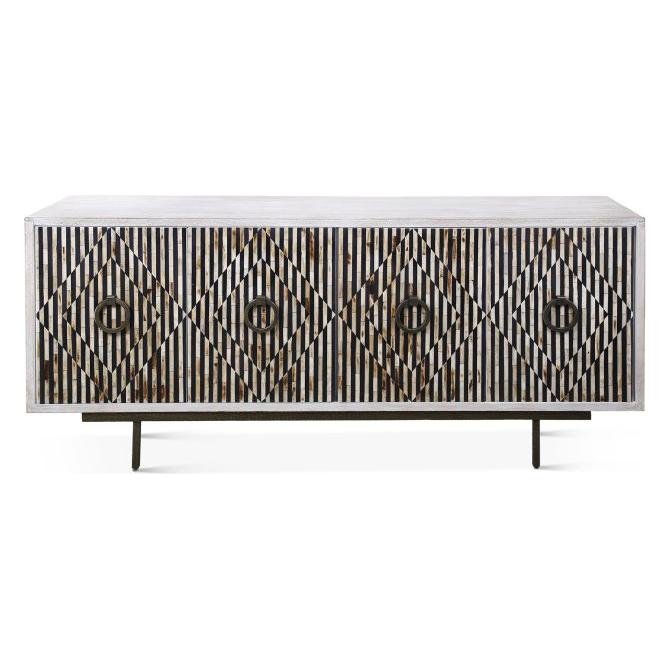 The Terra Noir Sideboard Media Cabinet is a rectangular wooden piece made from horn and mango wood. It features geometric diamond patterns of vertical black and white stripes across four cabinet doors and stands on slim metal legs for a modern, minimalist look.