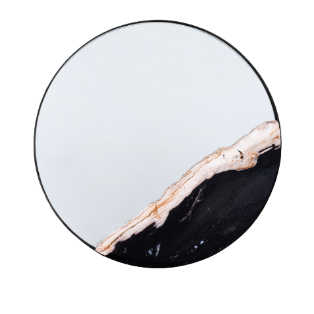 The Thalor Petrified Wood Accent Mirror is round with a smooth edge. Its lower right section features a contrasting light beige and black petrified wood accent, adding decorative flair to the plain reflective surface.