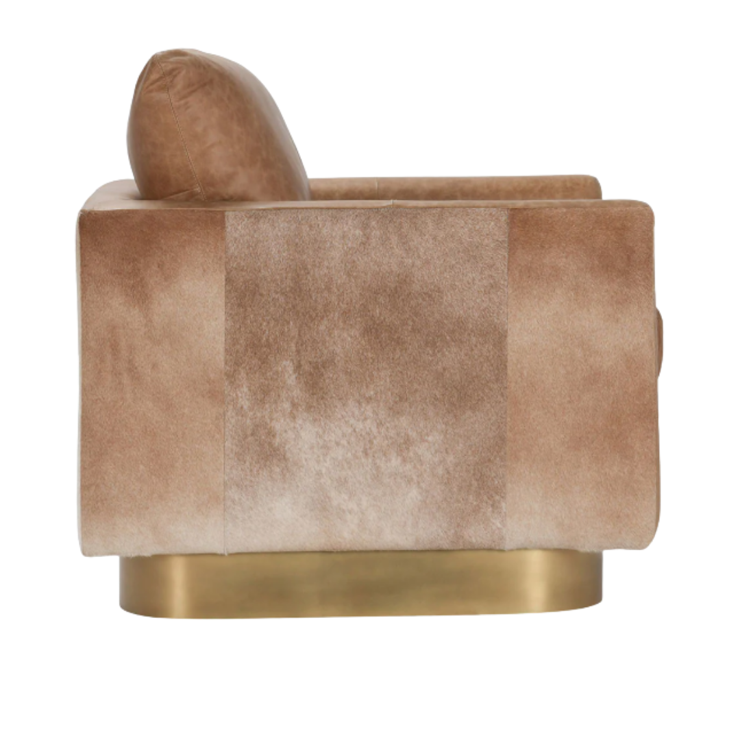 The Velancia Hide & Leather Swivel Chair offers a luxurious beige velvet side view with a plush high backrest and cushioned seat. Its cylindrical design, on a wide gold-toned metallic base, enhances modern glamour, while the textured fabric adds sophistication.