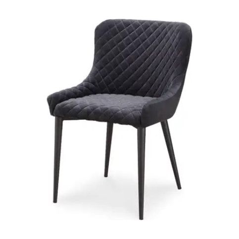 The Etna Dining Chair, a modern tufted treasure, boasts dark gray velvet upholstery with a quilted pattern on its cushioned backrest and seat. It features a slightly curved backrest and sleek, black metal legs that taper downwards.