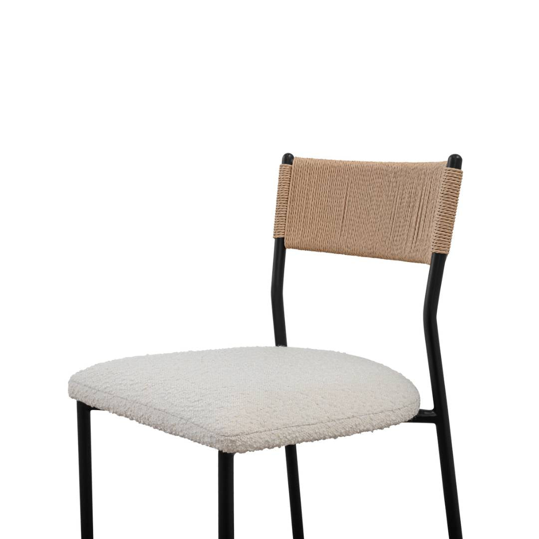 The Soren Performance Fabric Counter Stool features a black metal frame, textured beige performance fabric seat, and a light tan paper rope-wrapped backrest, offering a simple, minimalistic design against a plain white background.