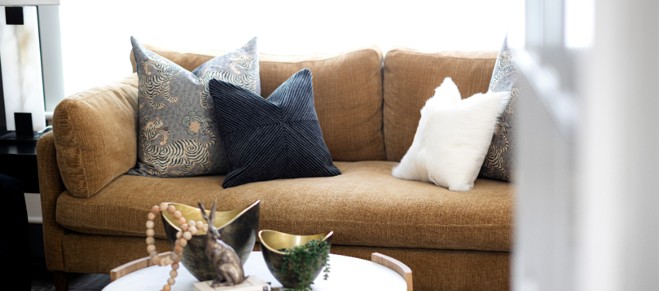 Neutral-toned living room sofa styled with layered accent pillows by Change Everything, Northern Colorado interior design