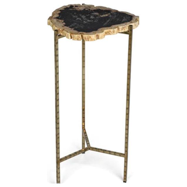 The Petrified Wood Martini Table features a small, irregular-edged black stone top with unique natural patterns. Supported by three slim gold-colored metal legs and a triangular base, it blends rustic charm and modern style.