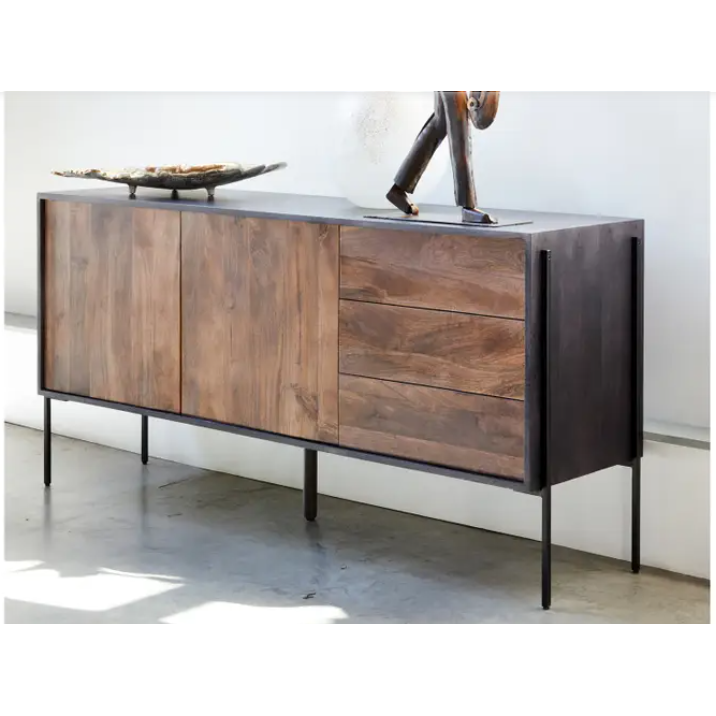 A modern Sona Sideboard crafted from solid mango wood with dark panels and slim, black metal legs. The sideboard has two doors and two visible handles. On top, there is a decorative bowl to the left and a tall, slender sculpture to the right, set against a white wall.