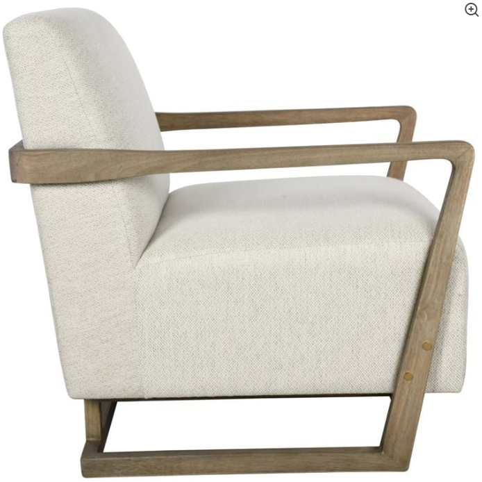 A modern Lea Accent Chair with a light beige polyester cushion and a sturdy wooden frame showcasing a minimalist design with clean lines and an open, airy structure. The chair features a low back and angular armrests.