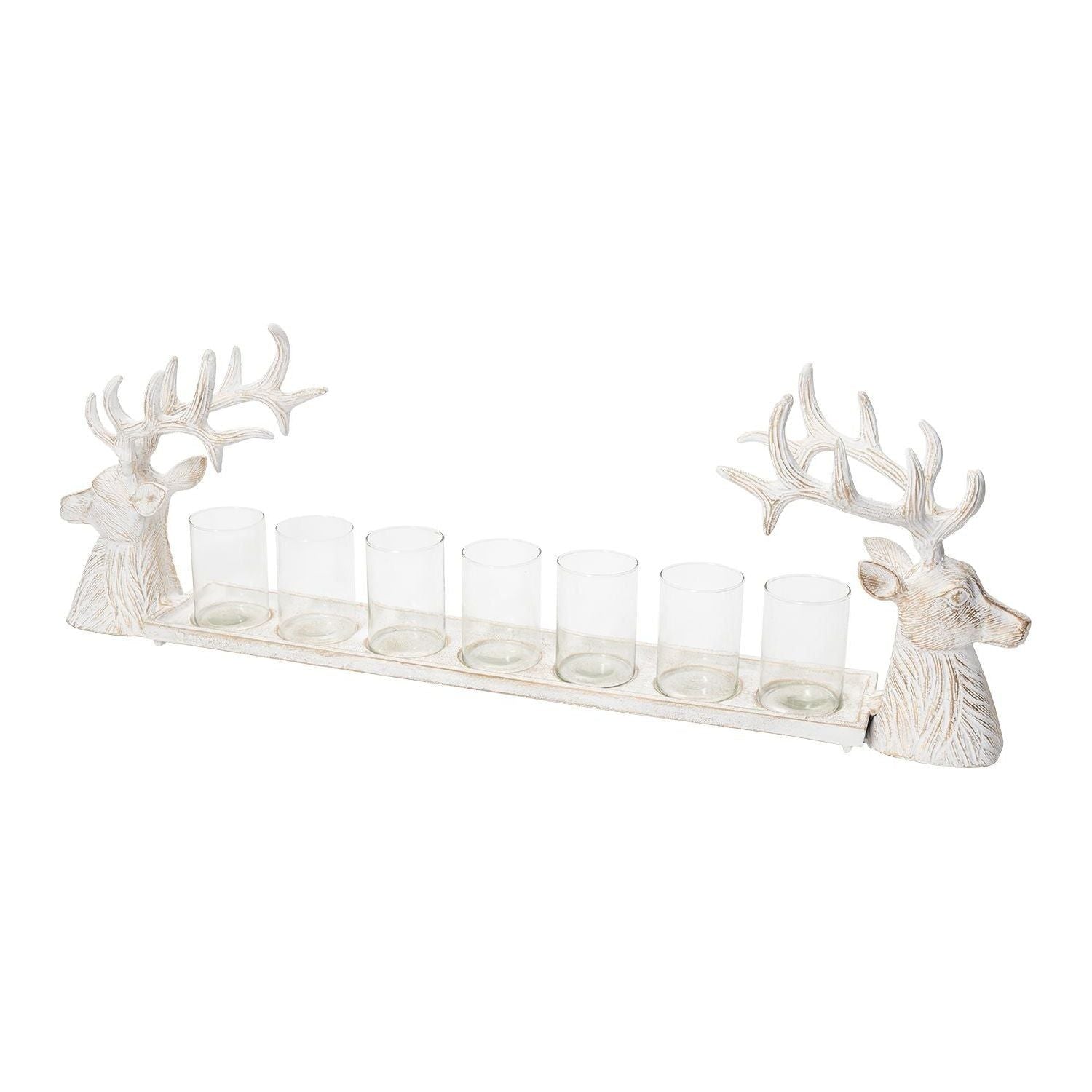 A Reindeer Candleholder measuring 35.0 x 6.5 x 11.5 inches features two detailed deer head sculptures on each end, each with large antlers. Between the deer heads are seven clear cylindrical glass holders evenly spaced out, perfect for candles or small items. The tray and deer are designed in a rustic, weathered white finish.