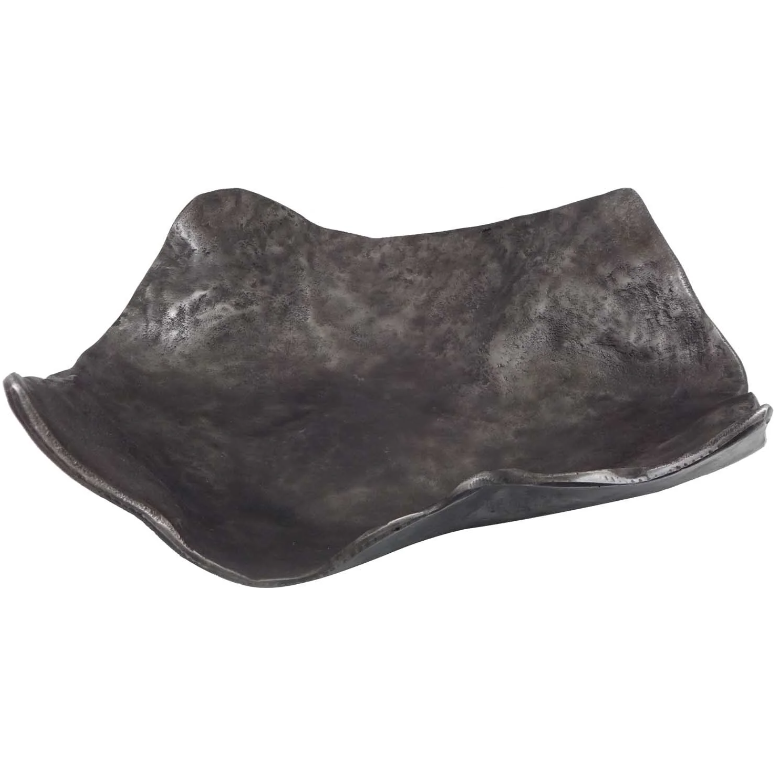 The Vaughan Wavy Charger is a matte black ceramic dish with wavy edges and an organic shape. Its uneven rim adds a flowing look, while the rough, stone-like texture enhances its unique design and rustic, handcrafted charm.