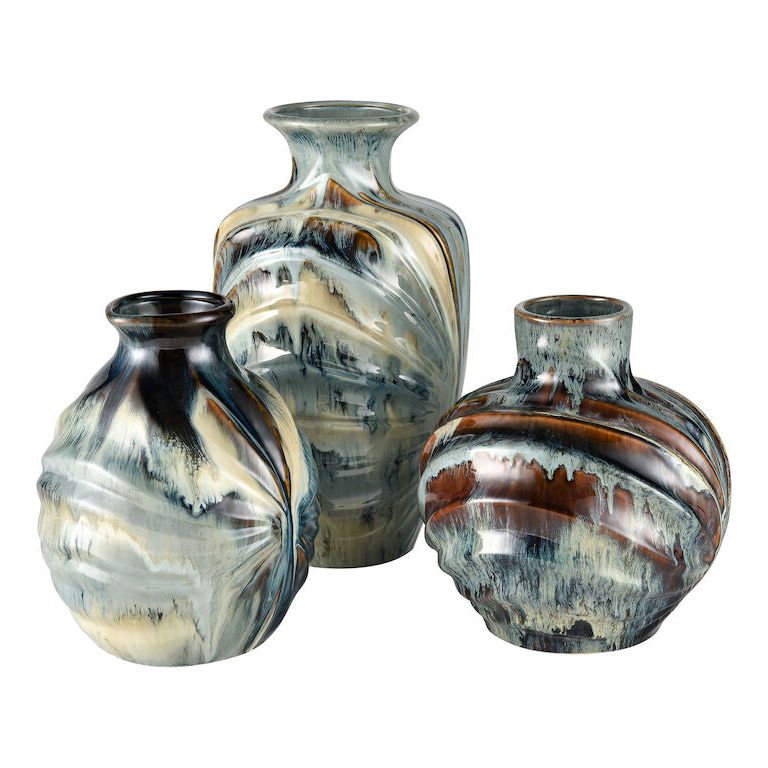 Three Earthenware Vases of varying heights and shapes with a distressed reactive glaze finish. The color palette includes shades of blue, brown, beige, and white, creating a swirling, abstract pattern. These Earthenware Vases are round with slightly flared necks and exude rustic charm when arranged in a group.