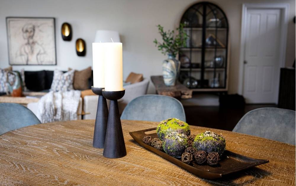 home displaying beautiful furniture including a dining table, turquoise chairs, and an arched cabinet