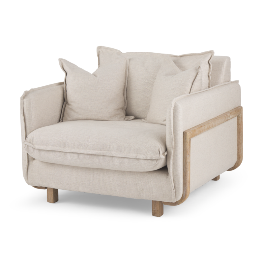 The Veyra Plush Upholstered Armchair, Beige, features a beige fabric with a solid oak frame and wooden accents. It includes cushioned seating, two matching throw pillows for comfort, and stands on four short wooden legs.