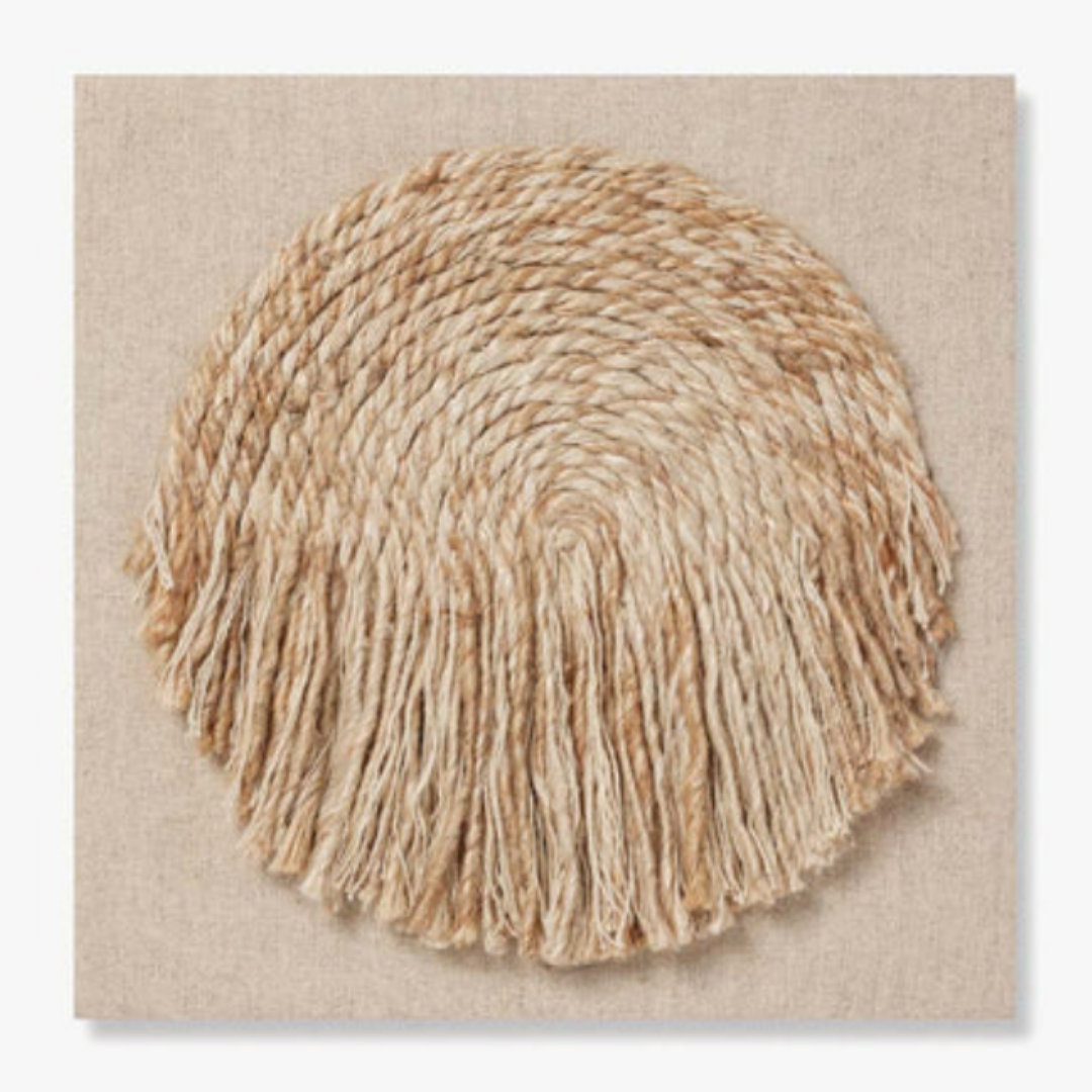 The Bellmont Woven Wool Boho Wall Art features a square canvas with a circular, braided jute design in natural beige tones. Thick rope spirals outward with cascading fringe at the edges, adding organic texture to any neutral space.