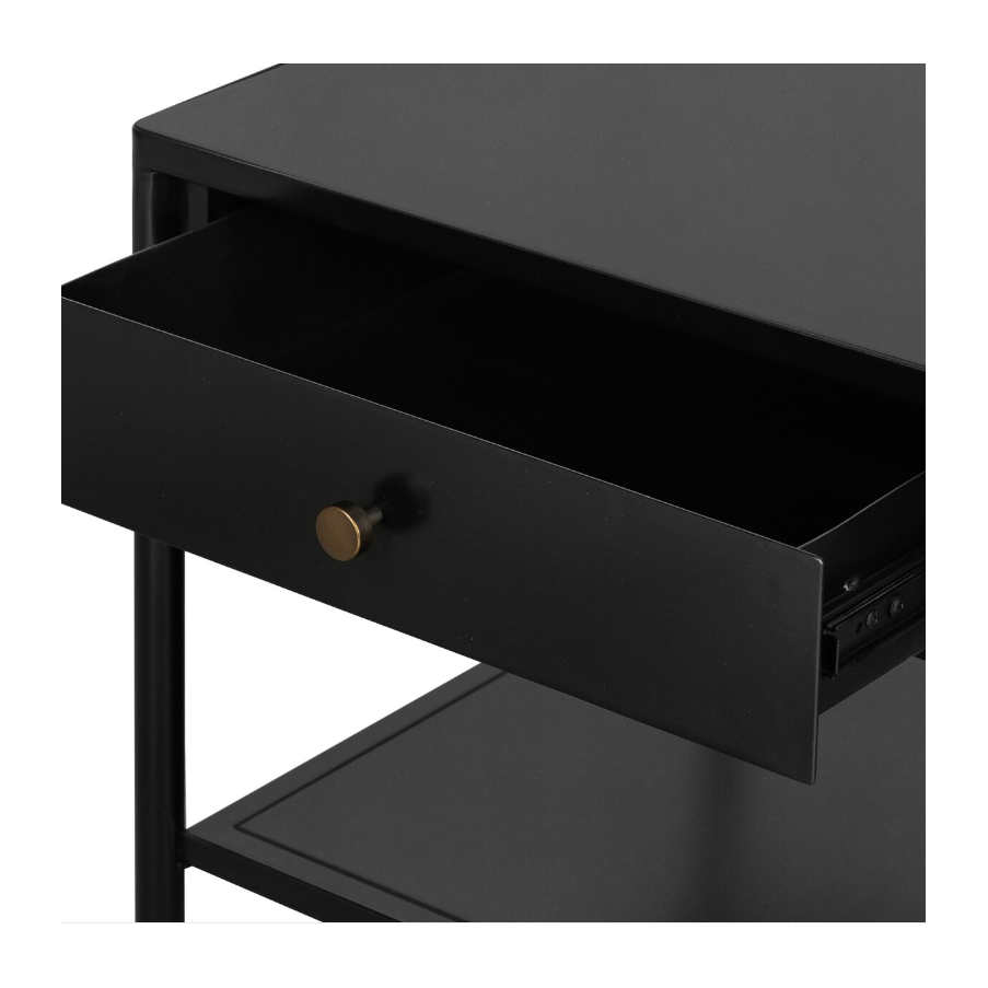 The Samuel Side Table boasts a black-finished iron frame and features a single open drawer adorned with a round brass knob, plus an additional lower shelf for extra storage. Its minimalist design and sleek metal structure lend it a contemporary and stylish appearance.