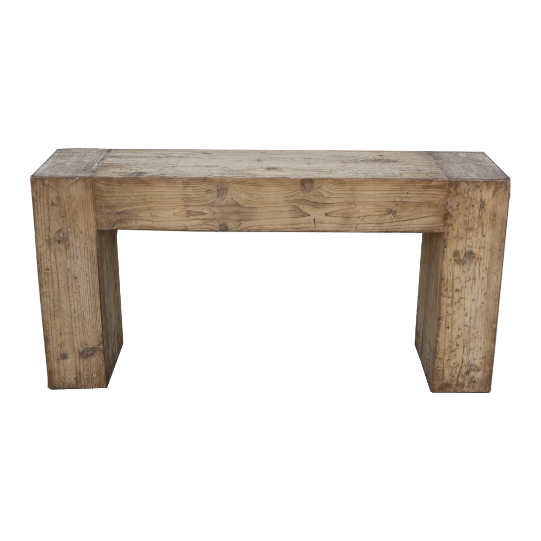 The Broadwell Console Table is made from reclaimed pine, showcasing natural wood grain and knots. It has a simple rectangular design with two sturdy side legs, offering a robust and minimalist look against a plain white backdrop.