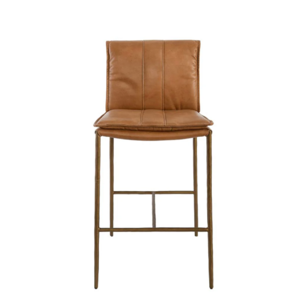 Introducing the Calder Leather Counter Stool: a modern and minimalist bar stool with a cushioned brown leather seat and backrest. Vertical stitching accents its sculptural metal frame finished in gold, complete with a footrest.