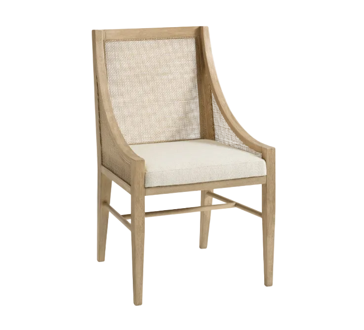 A light oak dining chair with a curved wooden frame, woven cane backrest, and cream-colored upholstered seat cushion, shown against a plain white background.