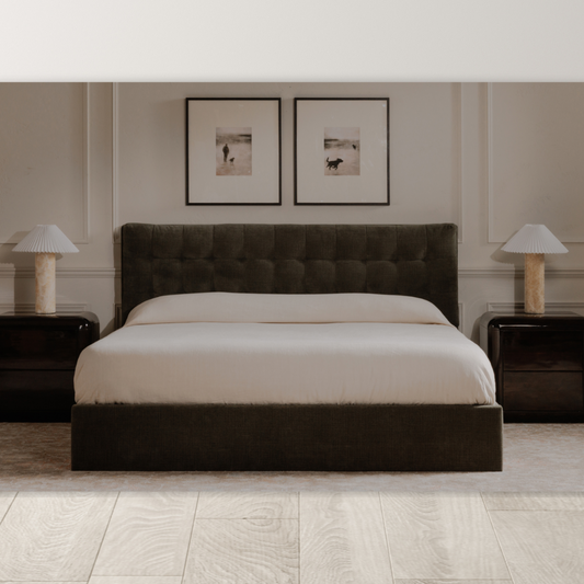 A modern bedroom showcases the Corveline Green Storage Bed with a tufted headboard, white bedding, two dark wood nightstands with matching lamps, framed photos above, and light wood floors for a calm, minimalist atmosphere.