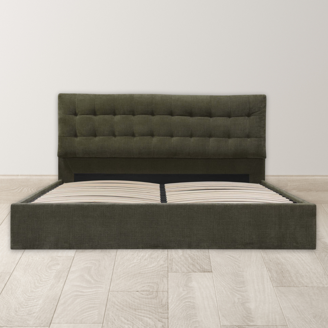 The Corveline Green Storage Bed features a modern dark green upholstered frame with a tufted headboard and wooden slats, shown without a mattress. It stands against a white wall on light wood flooring, combining style and smart storage.