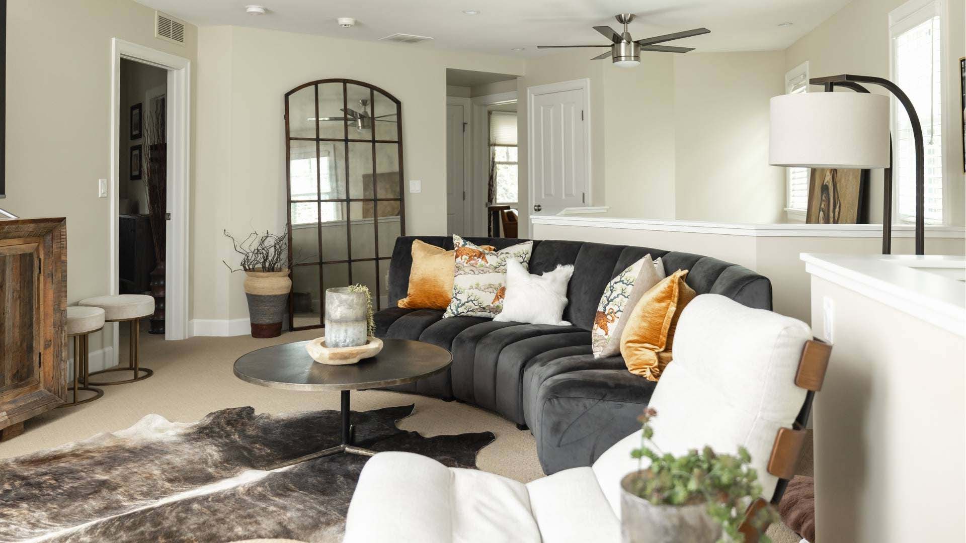 Living room with a gray sectional sofa, white armchair, and decorative pillows.