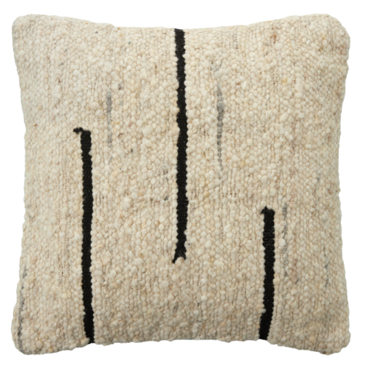 The Dillon Wool Pillow is a square, cream-colored cushion with a soft, textured weave and three uneven vertical black lines on the front, offering a modern, minimalist look. Plush and comfortable, it resembles a cream and black woven rug.