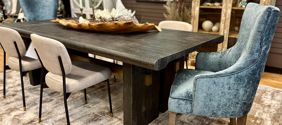 picture of a furniture store in fort collins. wood dining table in black with a pewter wingback captain chair