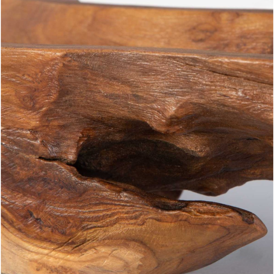 The Luvira Teak Leaf Bowl is a beautifully crafted wooden sculpture made from natural teak, showcasing smooth curves and intricate grain patterns in shades of brown. Its organic form emphasizes movement with unique variations in finish.