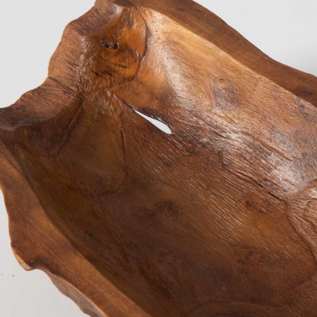 The Luvira Teak Leaf Bowl, crafted from natural teak wood, exhibits a textured, organic finish with rugged surfaces and visible grain. Its unique handcrafted charm is highlighted by irregular edges and variations in finish, enhancing its rustic allure against a plain background.