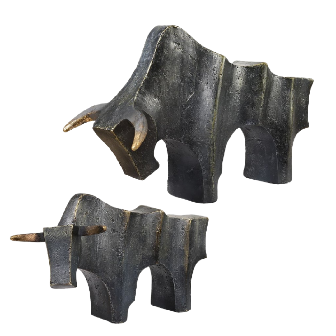 The Noble Bull Statue features two modern abstract bulls crafted in dark textured metal with a bronze finish and gold-highlighted horns. Their geometric, angular forms stand out against a white background.
