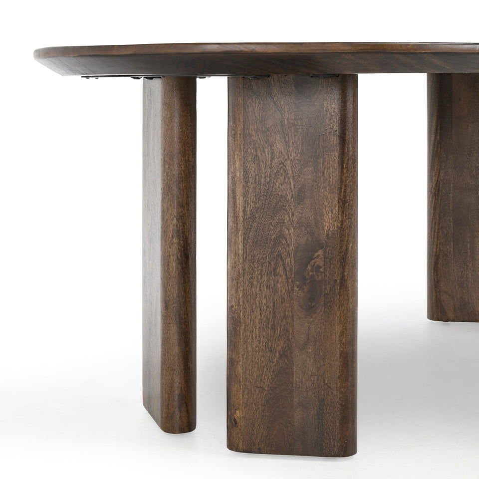 Wooden table with a round top and thick cylindrical legs on a white background