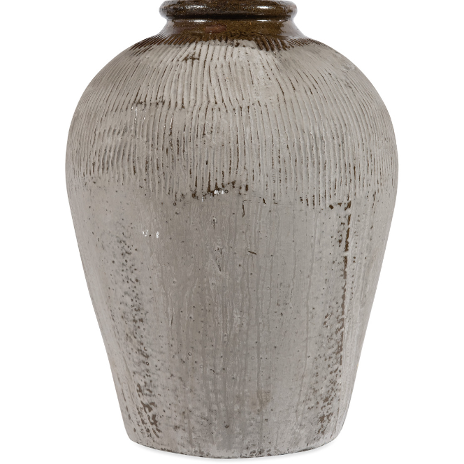 The Rice Wine Jar, Medium is a textured, off-white ceramic vase featuring vertical ridges and a glossy finish. It has a slightly tapered neck and displays a subtle color gradation from darker near the neck to lighter at the base. The jar's rustic, handmade appearance suggests an artisanal quality that adds a vintage touch to any decor.