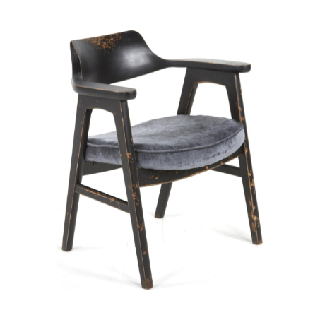 The Vintage Dining Chair in Antique Black exudes rustic charm with its distressed finish, curved backrest, angled armrests, and round pewter upholstered seat. Slightly splayed legs enhance stability for this elegant dining chair.