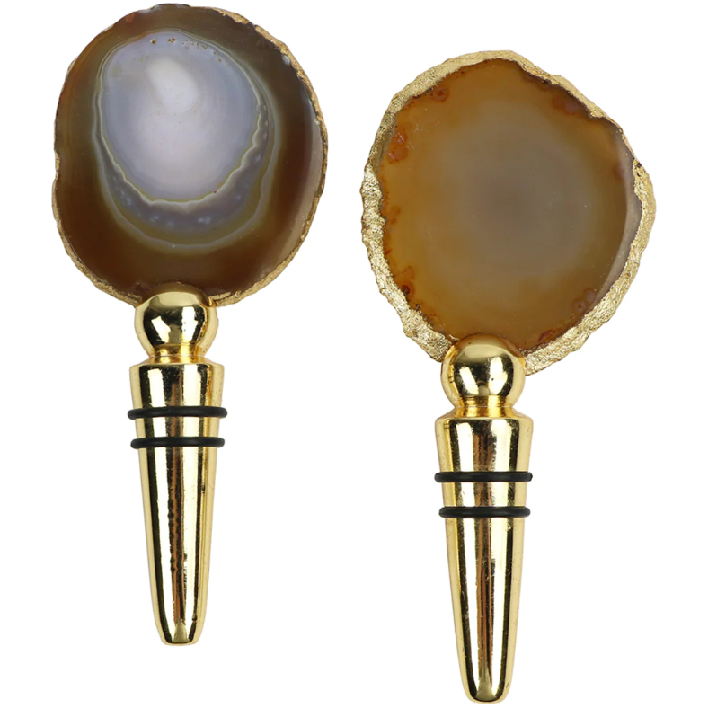 Explore our Agate Wine Stoppers, featuring polished agate stones in earthy hues and a blue-grey heart. Set atop gold-toned bases, each unique stopper retains freshness with dual black rubber rings, making them perfect for wine preservation.