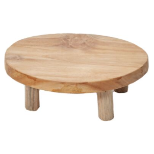 The Tejano Riser, a small, round wooden stand with a natural finish, exudes rustic elegance. It features a smooth surface and three short legs, while the high-quality wood grain is strikingly visible, enhancing its charm.