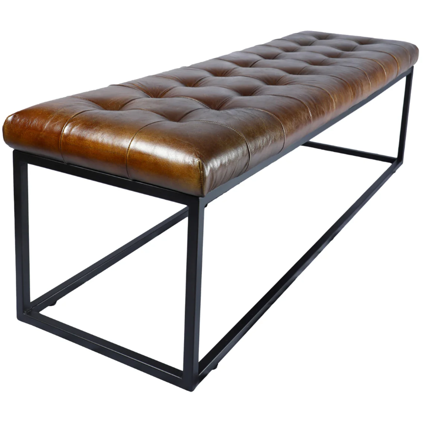 The Northwood Bench showcases a long, rectangular silhouette adorned with a brown, button-tufted leather cushion and a chic black metal frame. The diamond-shaped stitching gives it a quilted appearance. With its absence of backrest or armrests, this bench embodies modern minimalism and can also serve as an elegant coffee table.