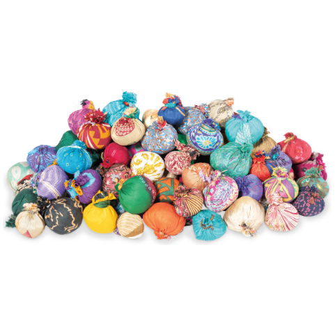 A large pile of Textile Balls is tightly packed together. Each handsewn bundle is wrapped in vibrant, patterned cloth with various designs, featuring hues such as red, blue, green, yellow, and purple. Made from reclaimed silk and tied at the top, they have a distinctive, festive appearance.