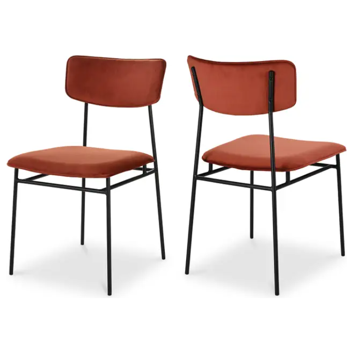 Two Elara Amber Dining Chairs, showcasing a minimalist design. Each chair features an armless structure with a sleek black metal frame and rust-red, foam-padded seat cushions. One chair is presented from the front, while the other is shown from the back, accentuating its clean and simple lines.
