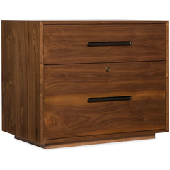 The Soren Walnut Lateral File is a wooden two-drawer cabinet with a warm walnut finish and visible grain. It features long black handles, a locking top drawer with keyhole, and a boxy design that sits flush to the floor—ideal for modular desks.