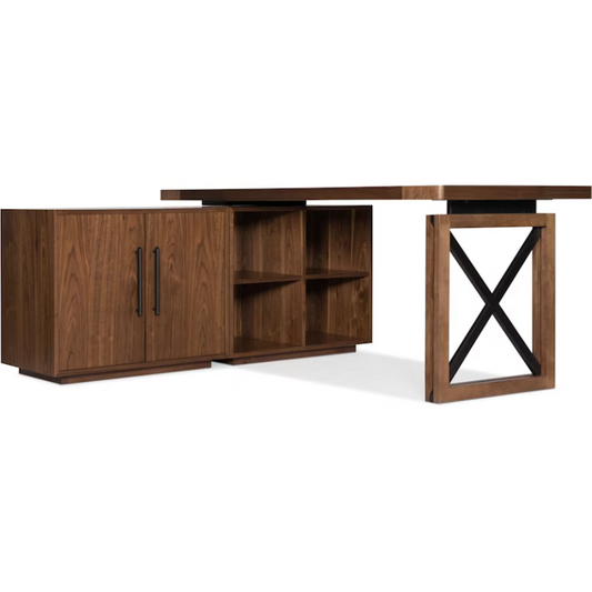 The Soren Walnut Modular Desk is a modern L-shaped desk featuring a rich walnut veneer finish. It includes custom built-in cabinetry with black handles on the left, open shelves in the center, and a sturdy frame with a black X-shaped support on the right, combining functionality with a contemporary aesthetic.