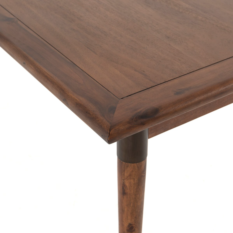 Close-up of the Teresa Extension Dining Table corner, highlighting the smooth, polished surface with natural grain patterns. The table features rounded edges and a tapered leg, showcasing Scandinavian modernism craftsmanship. The leg is partially visible and attached securely to the solid acacia wood tabletop.