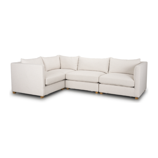 The Astrid Performance Fabric Modular Sectional Set is an L-shaped sofa in light beige, featuring cushioned backs and seats, low-profile squared armrests, performance fabric, and small light wooden legs on a seamless white background.