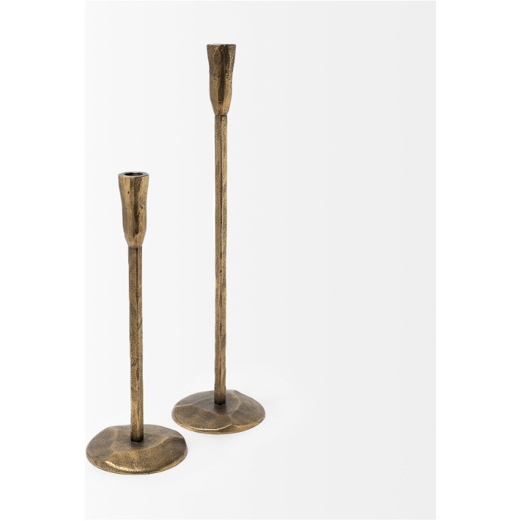 The Levi Gold Iron Candlestick set consists of a pair of vintage-style, minimalist candlesticks that exude rustic elegance with their weathered textures. The one on the left is shorter, while the one on the right stands taller. Each candlestick features a round base and an elongated cylindrical holder for the candles, all set against a plain white background.