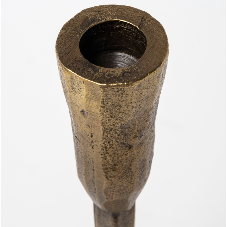 Close-up of the Levi Gold Iron Candlestick, featuring a brass-colored, textured metal finish and a hollow cylindrical shape that exudes rustic elegance. The surface is rough and uneven, displaying signs of wear. The top opening is circular, with the inside appearing dark. The plain white background accentuates its metallic finish.