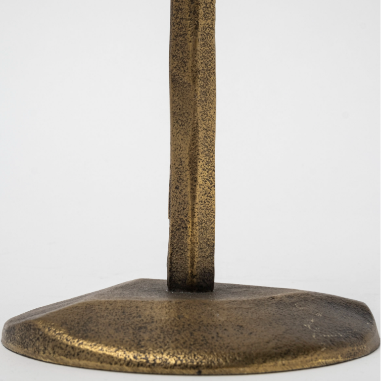 Close-up of the Levi Gold Iron Candlestick, featuring a bronze metallic stand with a textured, irregularly shaped base. The candlestick's vertical rod shares the same finish and embodies rustic elegance. A plain light gray background accentuates its timeless charm, perfectly blending art and functionality.