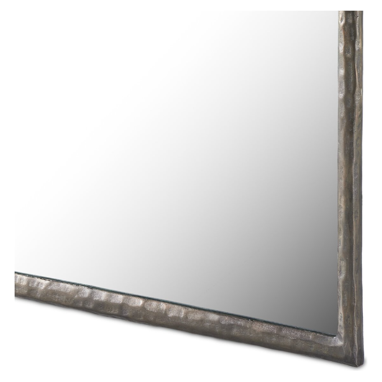 Close-up of a corner of the rectangular Hammered Nickel Wall Mirror. The mirror features a decorative beveled frame with a textured, hammered metal finish. The reflection in the mirror is a neutral blank white space, keeping the focus on the unique and rugged appearance of this standout piece in home decor.